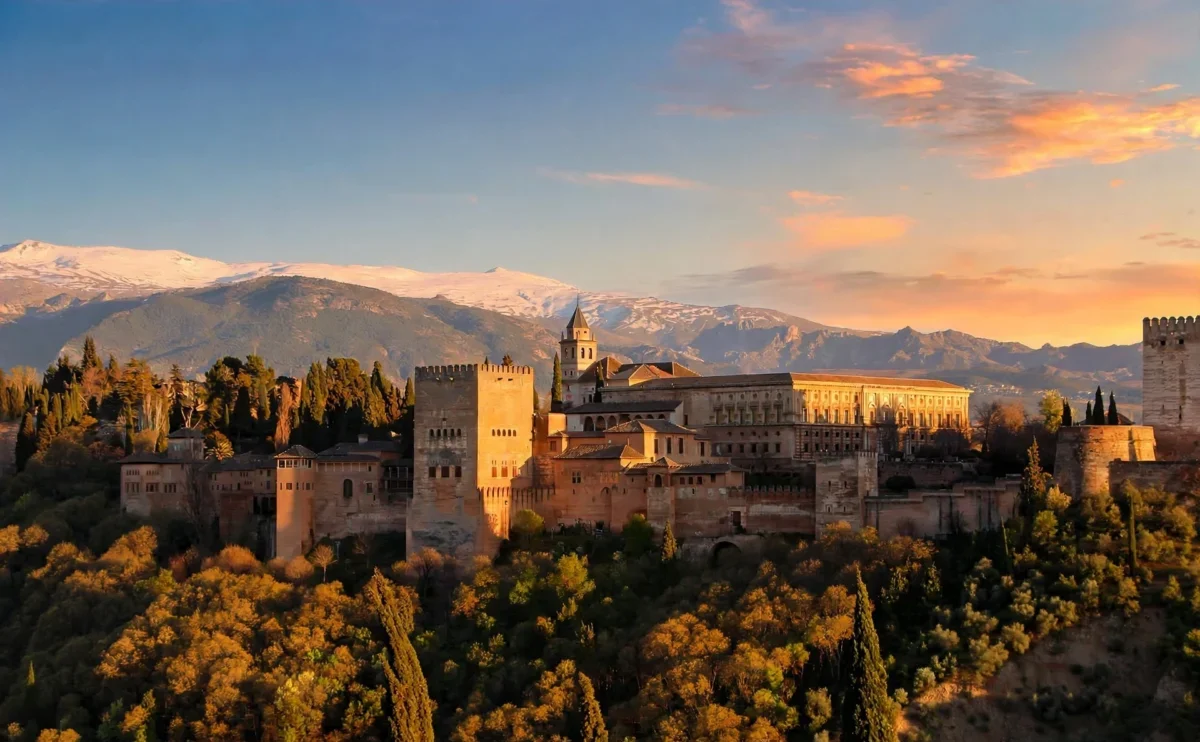 Alhambra Palace in Granada at sunset with snow-capped Sierra Nevada mountains - book Alhambra tickets in advance