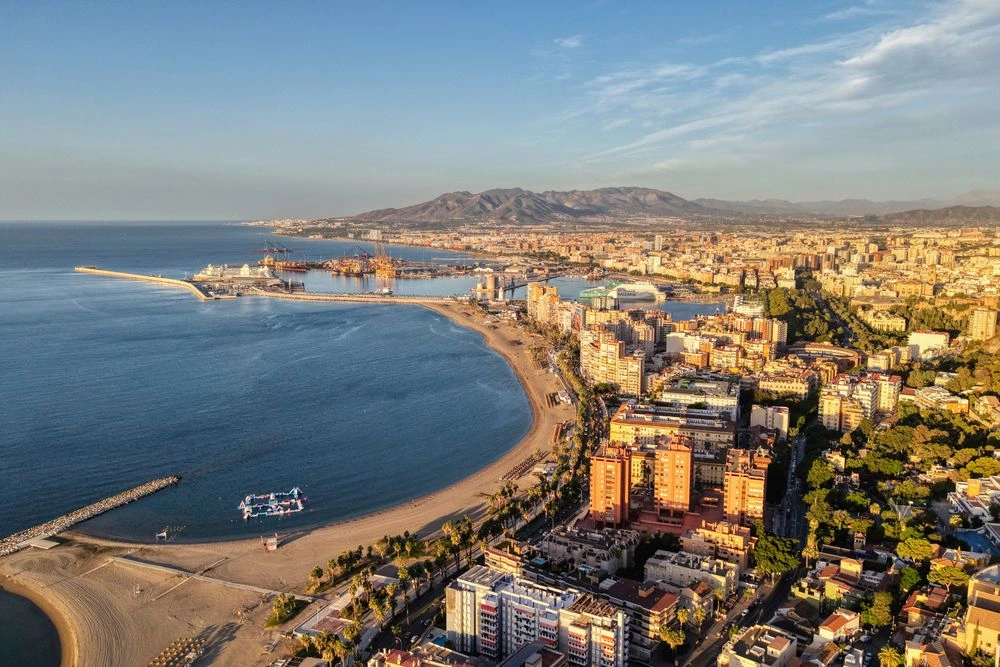 Pedregalejo Beach in Málaga, Spain Aerial view of people enjoying a beach under a blue sky