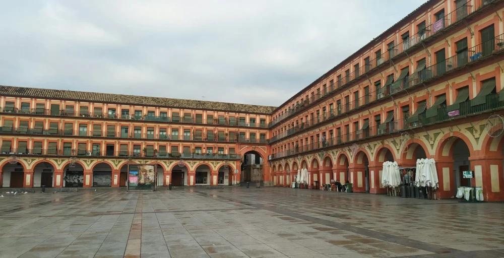 plaza de la corredera cordoba Plaza de la Corredera with colorful historic buildings and arcaded walkways in Córdoba, Spain.